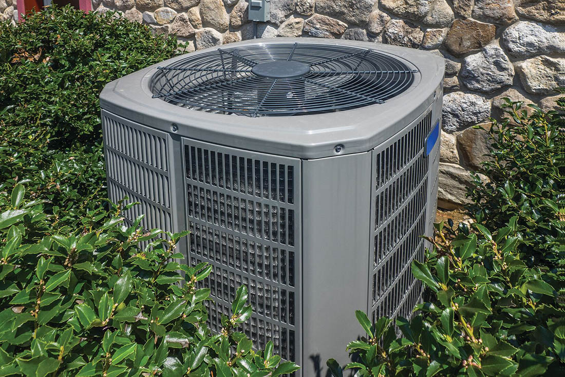heatPumps-HeatPumpReplacement-Supporting-1100×734 Heat pump on side of house surrounded by landscaping