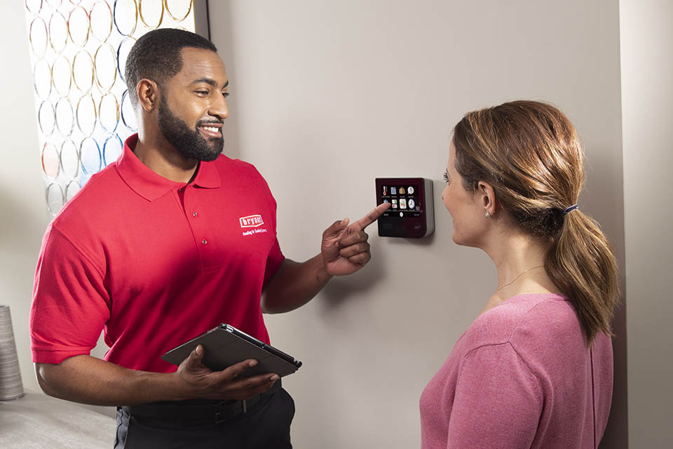 products-Bryant-Thermostat-2-960×640 technician showing homeowner a smart thermostat